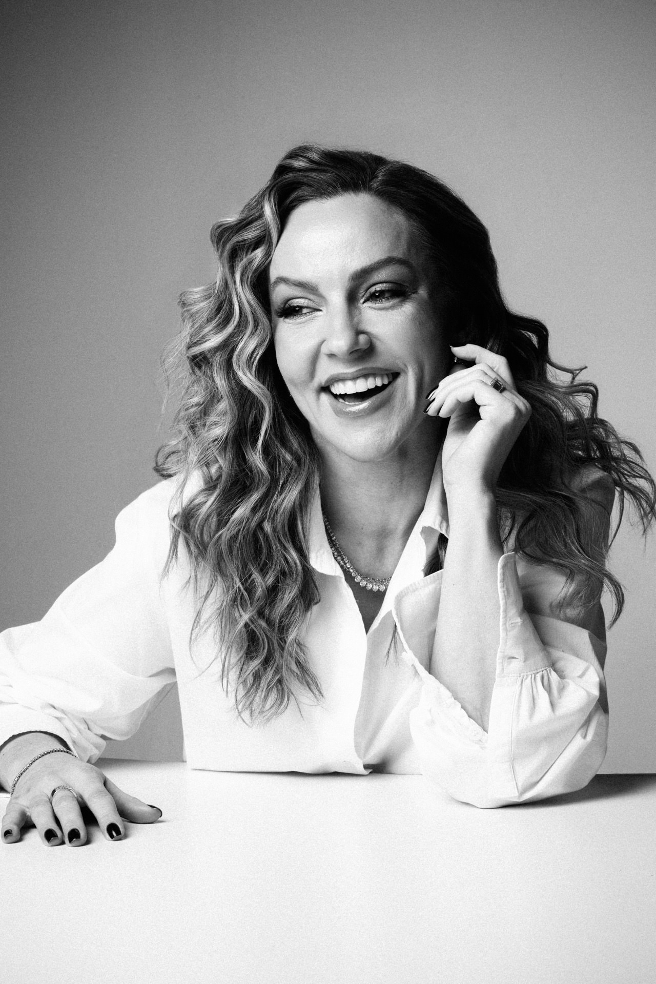 Susana Santin sorrindo em retrato corporativo preto e branco