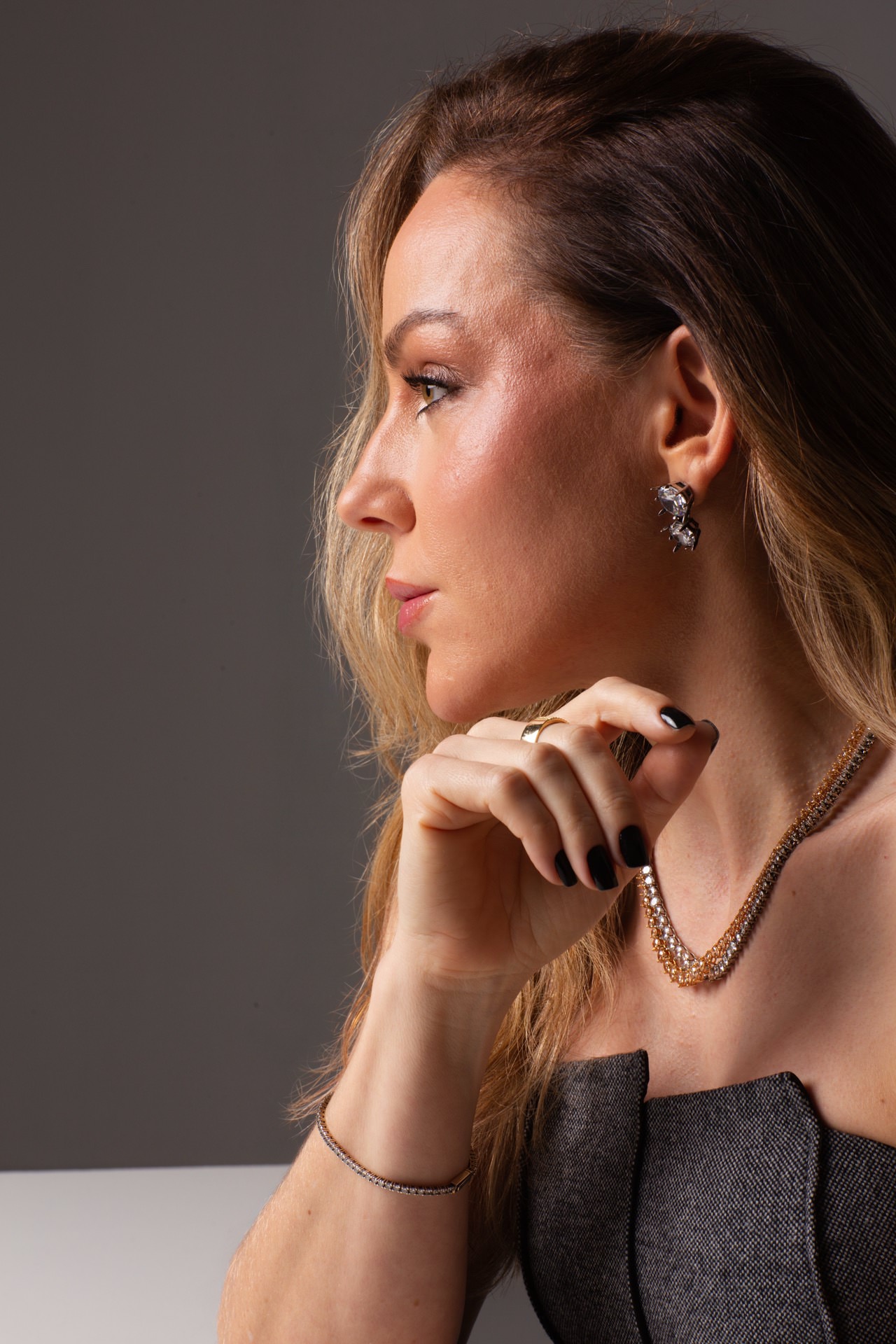 Perfil de Susana Santin com luz lateral e fundo escuro
