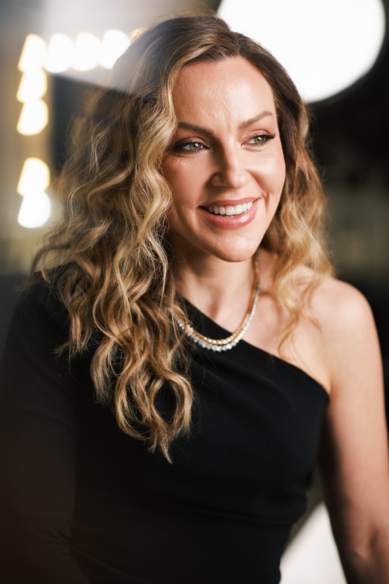 Susana Santin sorrindo em retrato profissional com luz de camarim